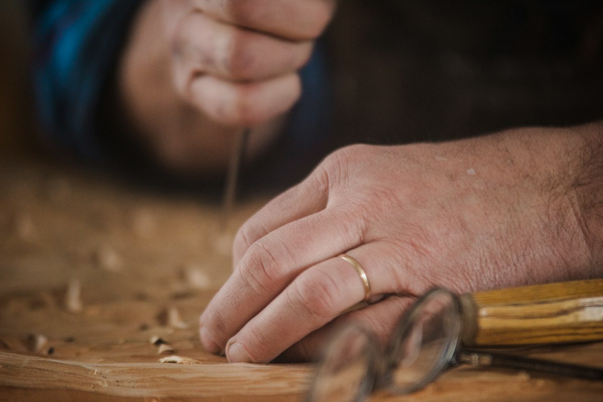 Hands working a piece of wood