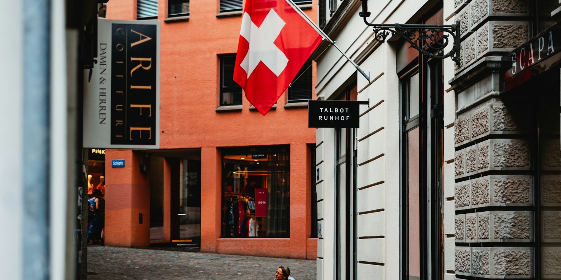A shop entrance in a Swiss old town street with the Swiss flag